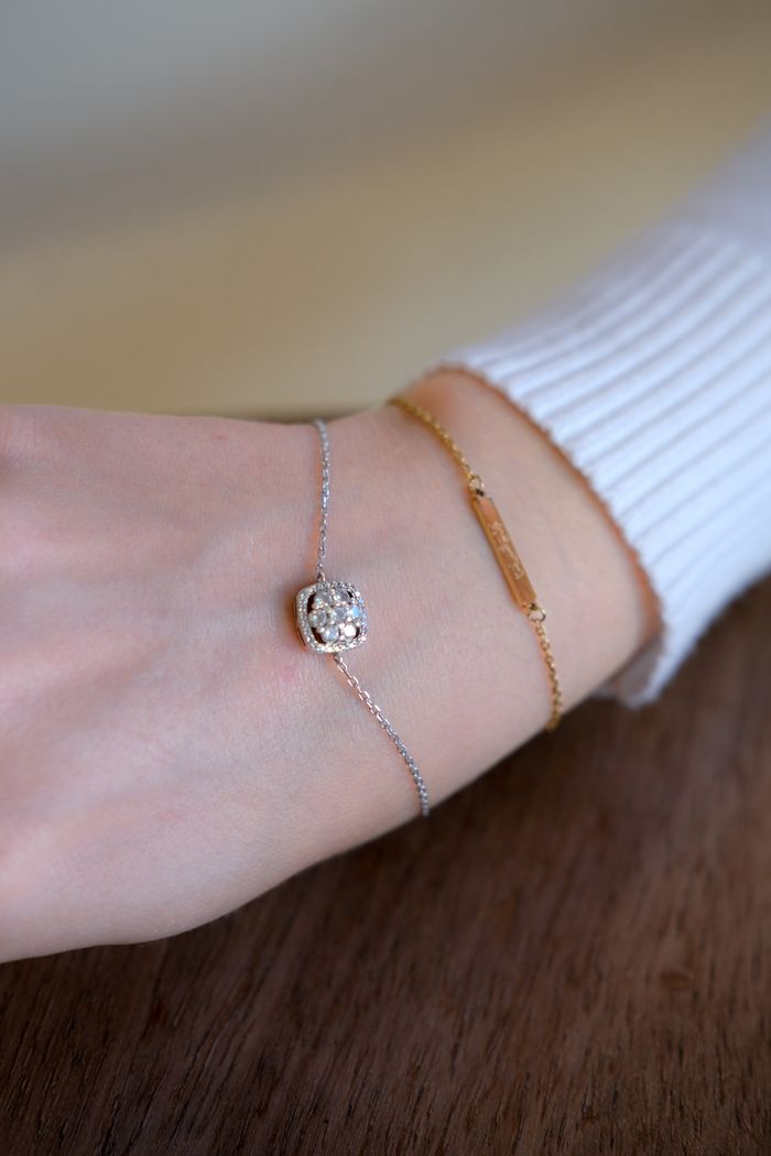 Close-up of a woman's wrist wearing a luxurious diamond and gold bracelet, highlighting elegance.